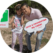 Hombre y niña enfrente del lote, con un cartel que dice voy a proyectar mi casa